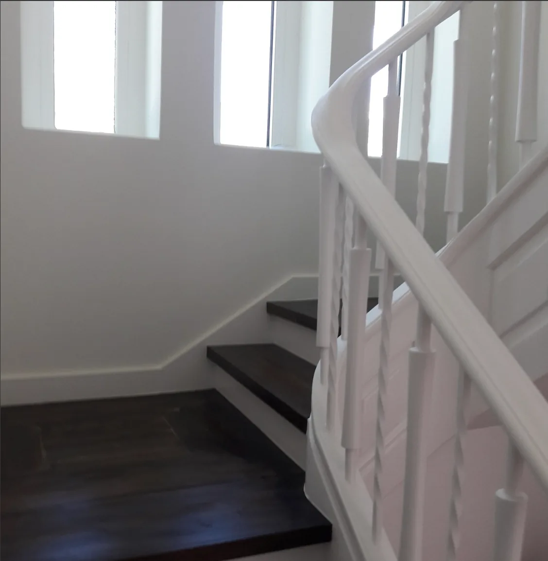 Escada interior antiga recuperada, com degraus em madeira e corrimão pintado de branco
