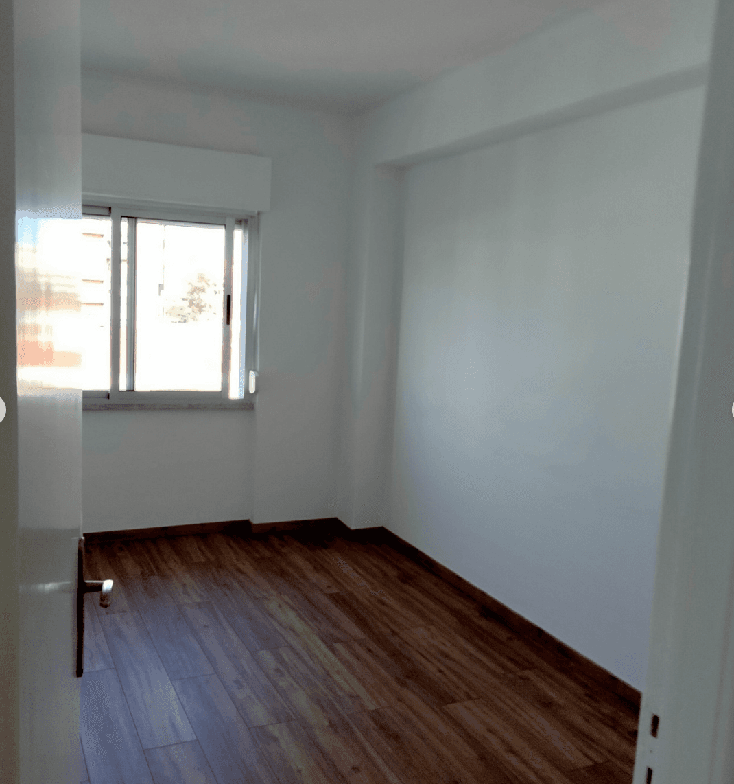 Quarto pintado de branco com pavimento em madeira
